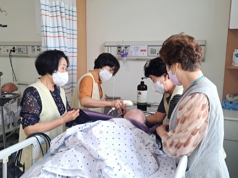 세발 봉사: 환자 한분의 세발을 여성 봉사자 4분이서 머리를 감겨주고 있는 모습