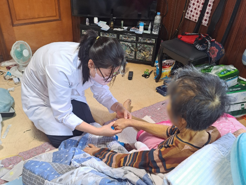 의료진 가정 방문: 여성 환자분을 여성 의료진 1분이 방문 진료하는 모습
